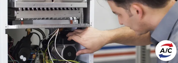 HVAC technician inspecting and repairing internal components of an air conditioning unit.